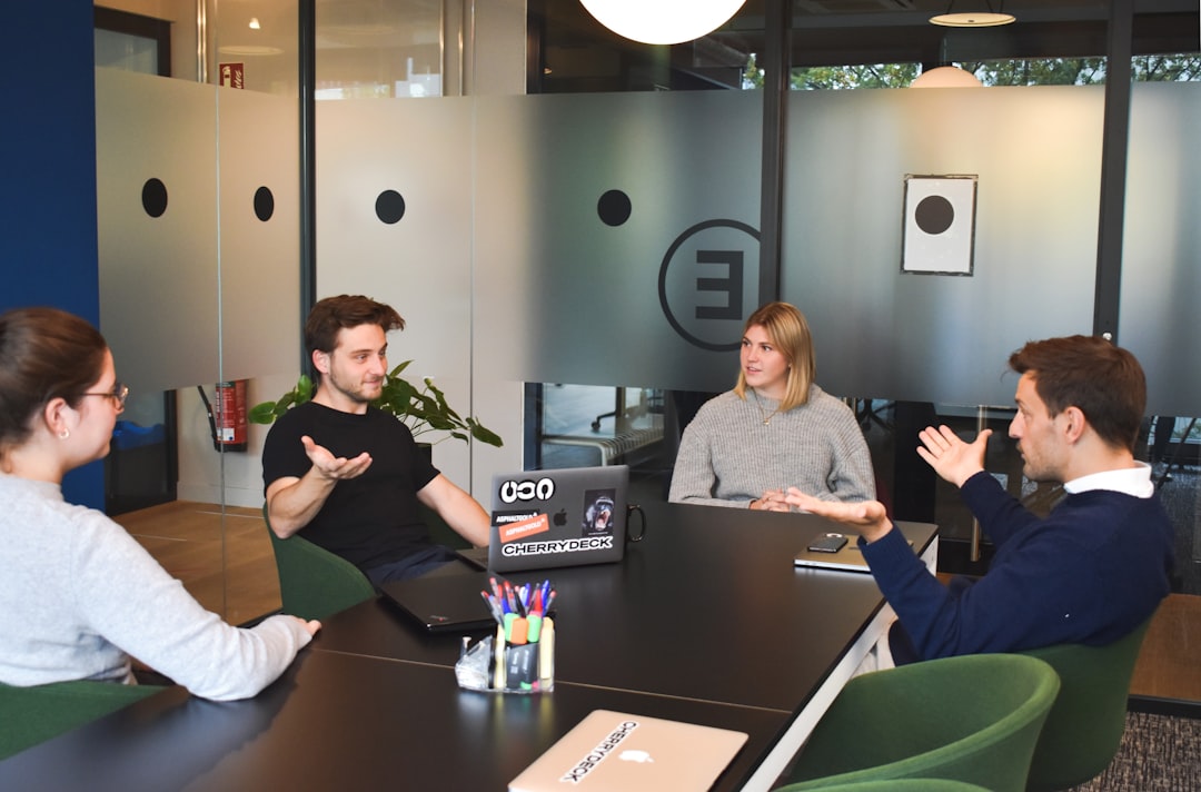 a group of people sitting around a laptop computer