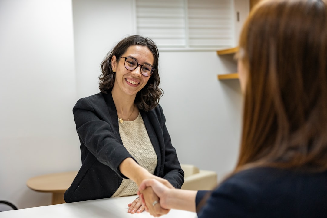 a man sitting at a desk talking to a woman