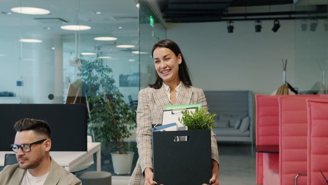 Man carrying box of belongings in modern office